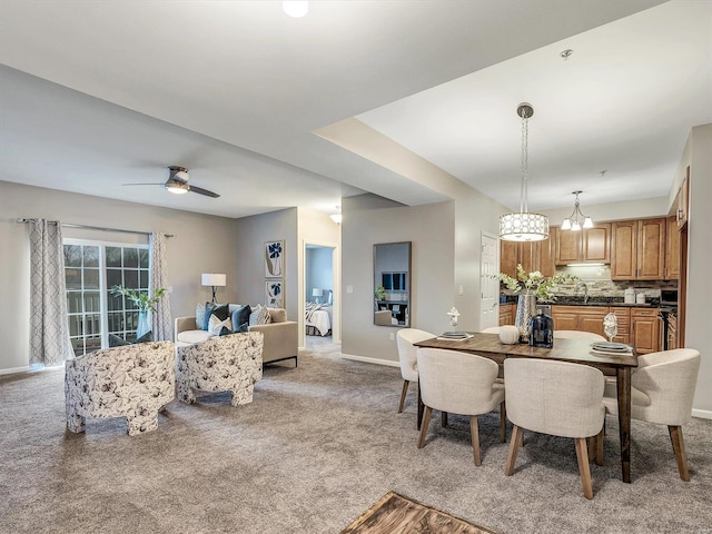 dining area featuring a ceiling fan, light carpet, and baseboards