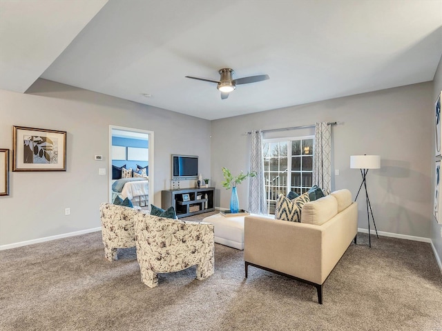 carpeted living area featuring ceiling fan and baseboards