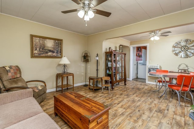 living room featuring crown molding, ceiling fan, wood-type flooring, and washer / clothes dryer