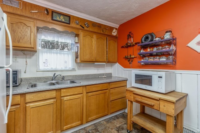 kitchen with refrigerator, sink, a textured ceiling, and backsplash