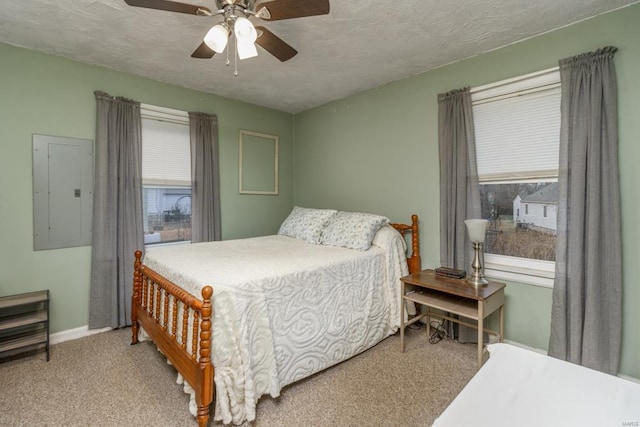 carpeted bedroom with ceiling fan, electric panel, and a textured ceiling