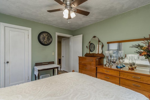 bedroom with ceiling fan and a textured ceiling