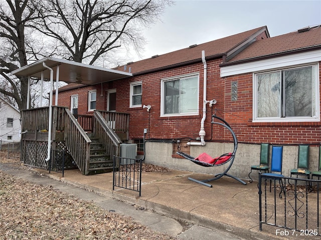 rear view of house with central AC unit and a patio