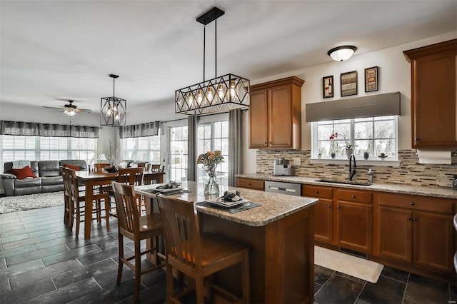 kitchen featuring sink, a kitchen island, hanging light fixtures, and decorative backsplash