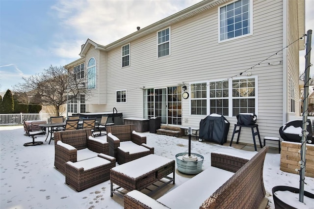 snow covered back of property with an outdoor hangout area