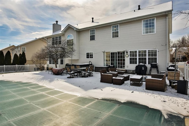 snow covered house featuring outdoor lounge area and a covered pool