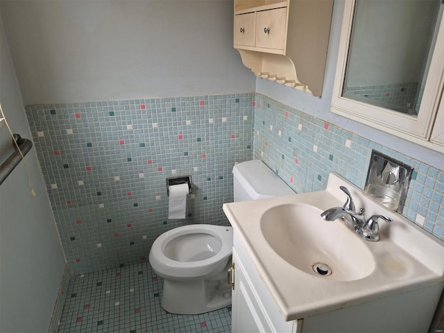 bathroom with tile patterned flooring, vanity, tile walls, and toilet