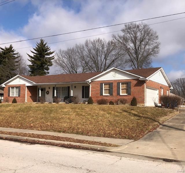 single story home with a garage, concrete driveway, brick siding, and a front yard