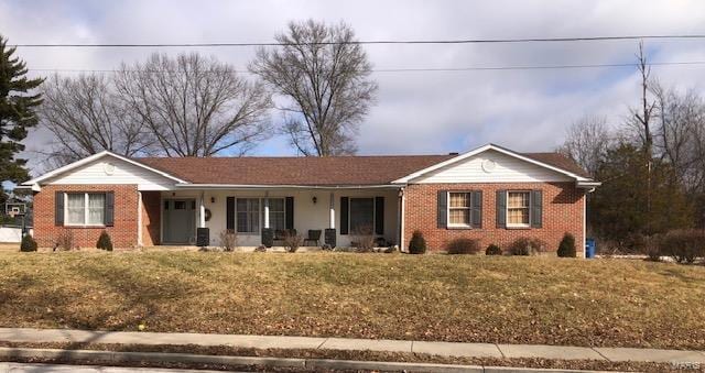 single story home featuring brick siding and a front yard