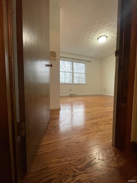 empty room with light wood finished floors and baseboards