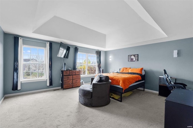 bedroom featuring carpet flooring, a raised ceiling, and baseboards