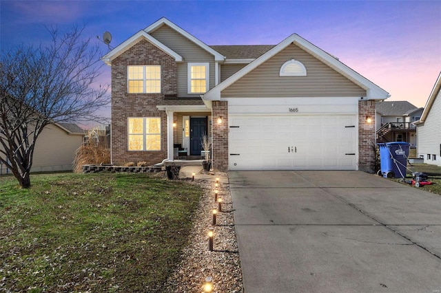 traditional-style home featuring an attached garage, driveway, a front yard, and brick siding