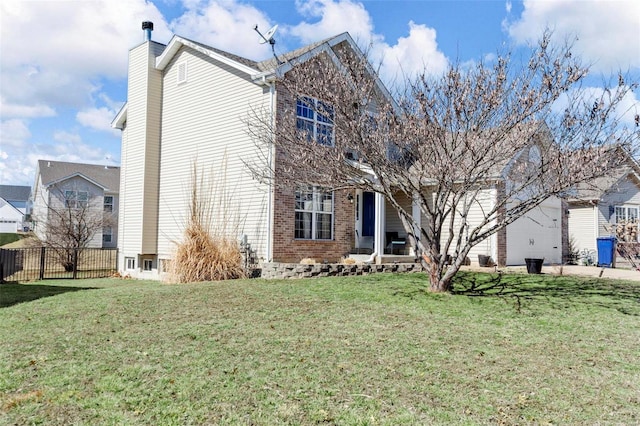 traditional-style house featuring brick siding, fence, and a front lawn