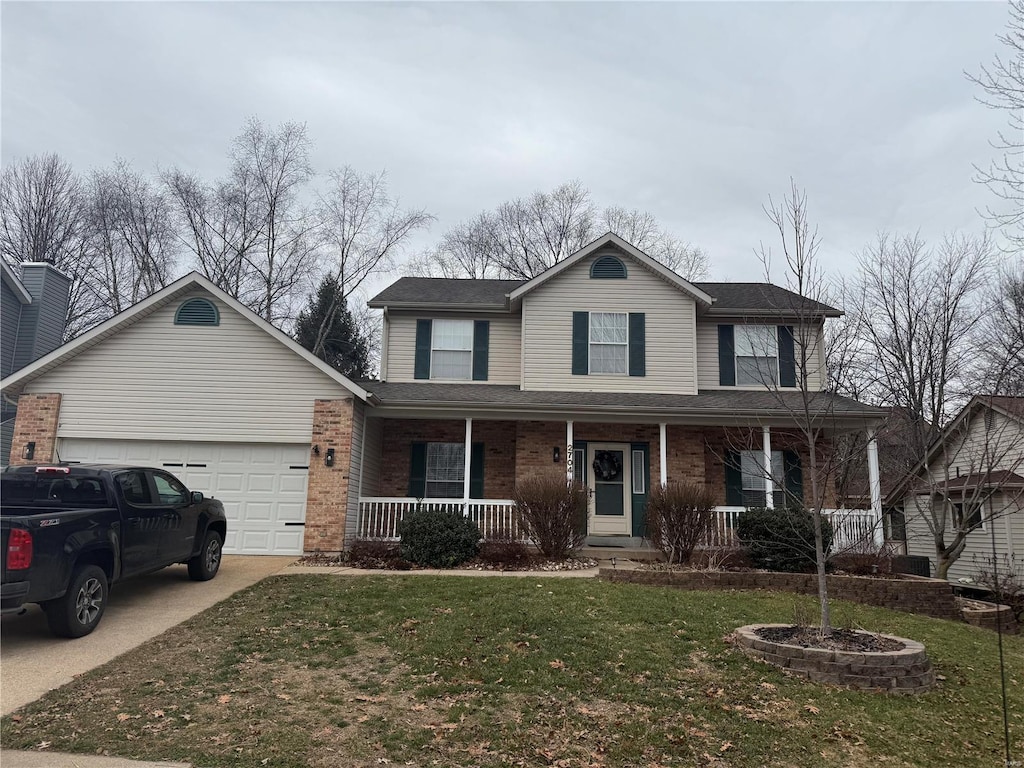 front of property featuring a garage, a front lawn, and a porch