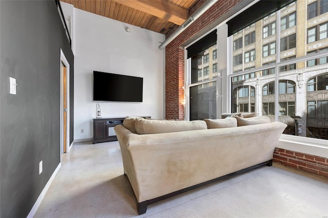 living room featuring wood ceiling, beamed ceiling, baseboards, and concrete floors