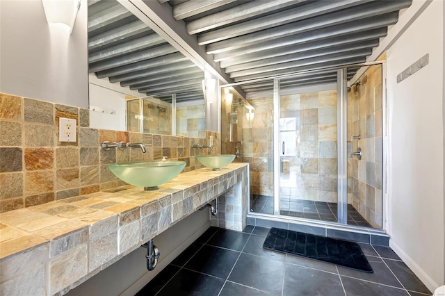 full bathroom featuring tile patterned floors, a stall shower, and a sink