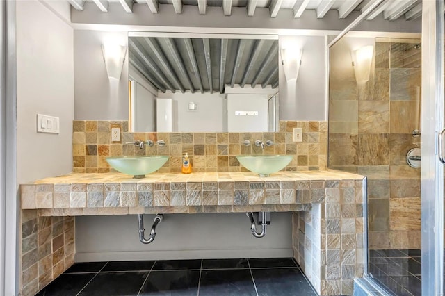 bathroom with a shower stall, tile patterned floors, and a sink