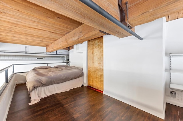 bedroom featuring beamed ceiling, wood ceiling, and wood finished floors