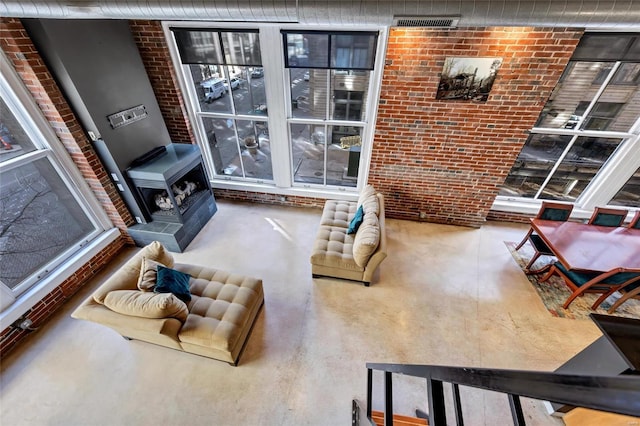 living room with brick wall and finished concrete floors