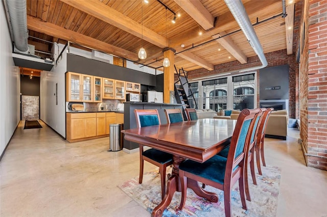 dining space with wooden ceiling, beamed ceiling, rail lighting, and finished concrete floors