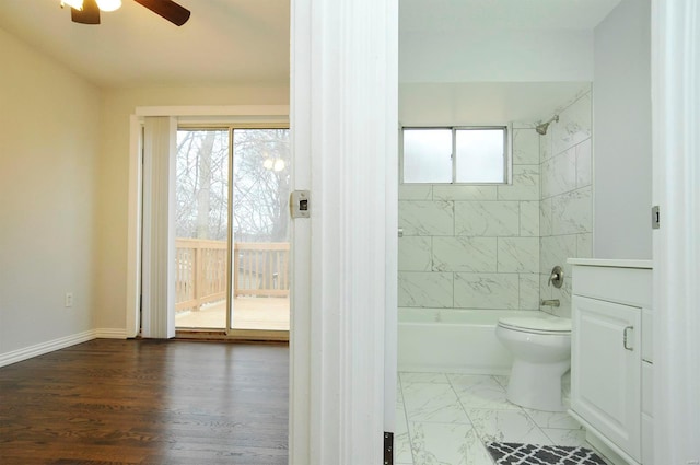 bathroom with ceiling fan, tiled shower / bath, and toilet