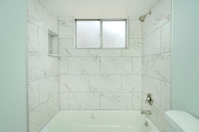 bathroom featuring toilet and tiled shower / bath combo