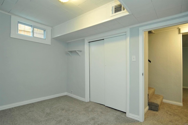 basement featuring crown molding and light carpet