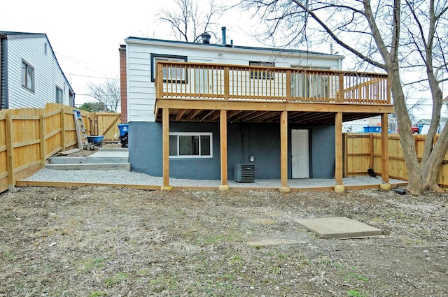 rear view of property with a wooden deck and central AC unit