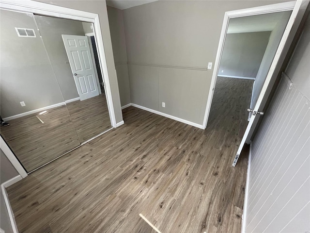 unfurnished bedroom featuring wood-type flooring and a closet