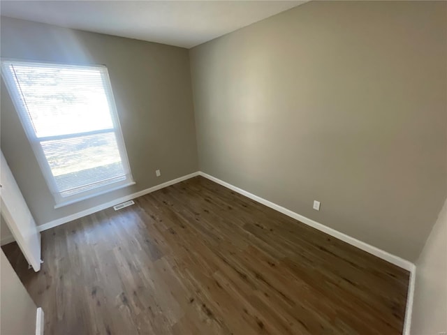 spare room with dark wood-type flooring