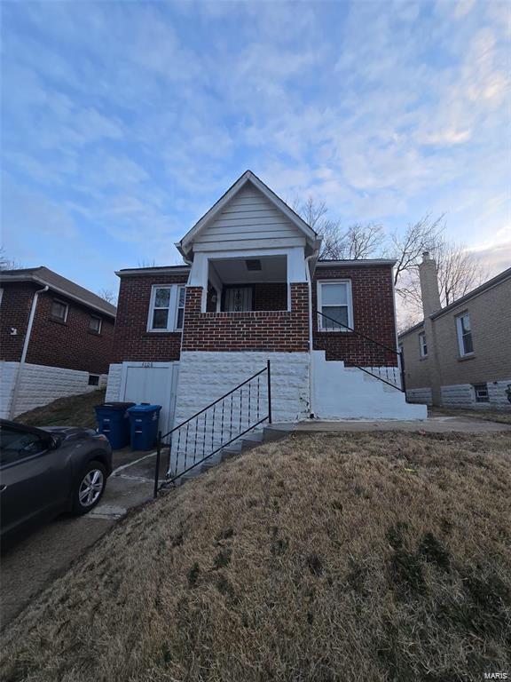 view of front of property featuring a front yard and brick siding