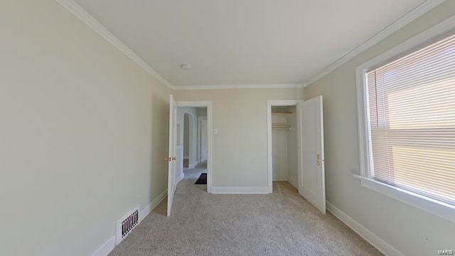 unfurnished bedroom featuring light carpet, crown molding, visible vents, and baseboards