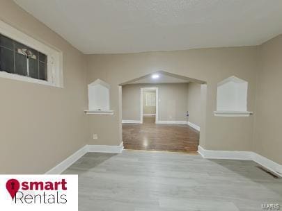 empty room featuring baseboards and wood finished floors