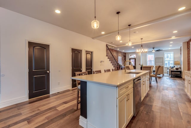 kitchen featuring pendant lighting, sink, hardwood / wood-style flooring, a kitchen island with sink, and stainless steel dishwasher