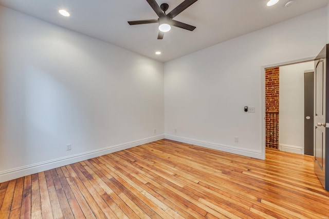 spare room with ceiling fan and light wood-type flooring