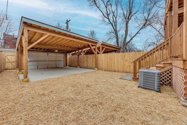 view of yard with a garage and central air condition unit