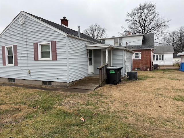 back of property with a yard and central AC