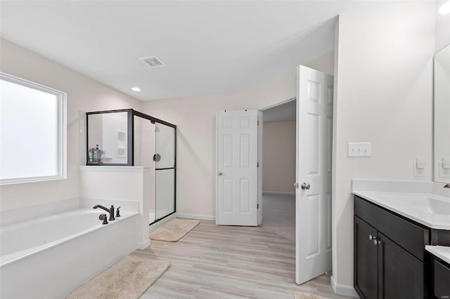 bathroom with vanity, separate shower and tub, and hardwood / wood-style floors