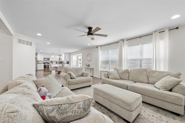 living room with ceiling fan and light wood-type flooring