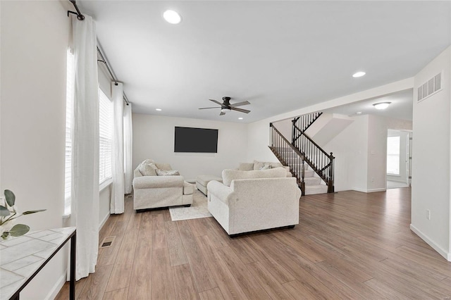 living room with light hardwood / wood-style floors and ceiling fan