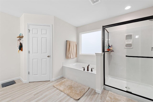 bathroom featuring wood-type flooring and independent shower and bath