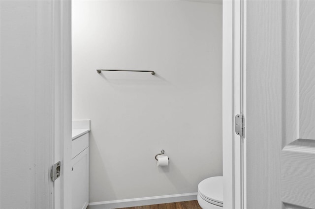 bathroom featuring vanity, wood-type flooring, and toilet