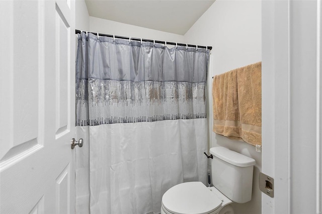 bathroom with a shower with curtain and toilet