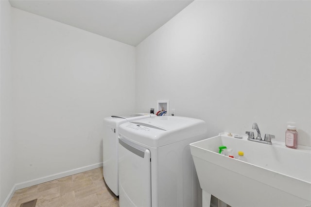 clothes washing area with sink and washing machine and clothes dryer