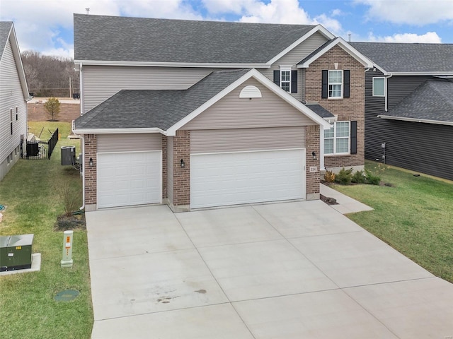 view of front of property featuring cooling unit, a garage, and a front yard