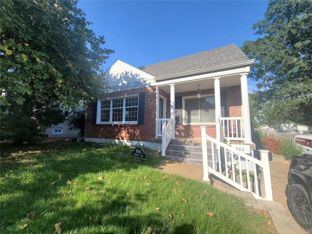 view of front of home with a front yard and covered porch