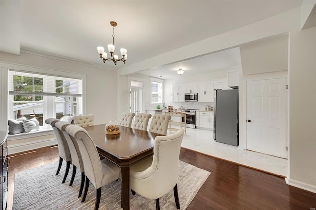 dining space with a notable chandelier and hardwood / wood-style floors