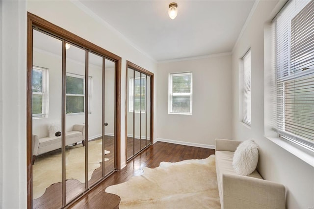 sitting room with crown molding and dark wood-type flooring