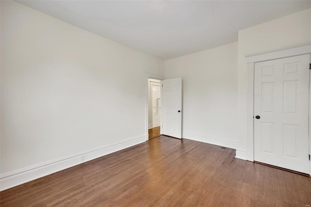 unfurnished bedroom with dark hardwood / wood-style flooring