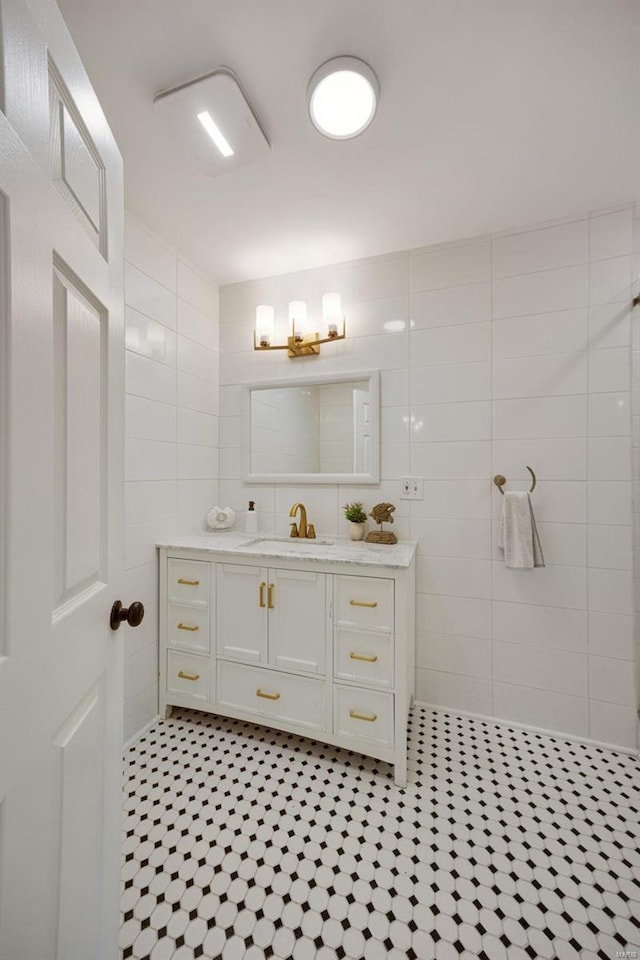 bathroom with vanity and tile walls